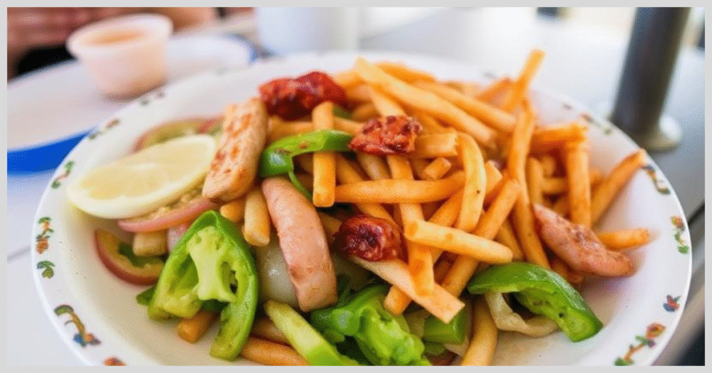 A plate of golden French fries and colorful vegetables, garnished with a lemon wedge, served on Gili Island.